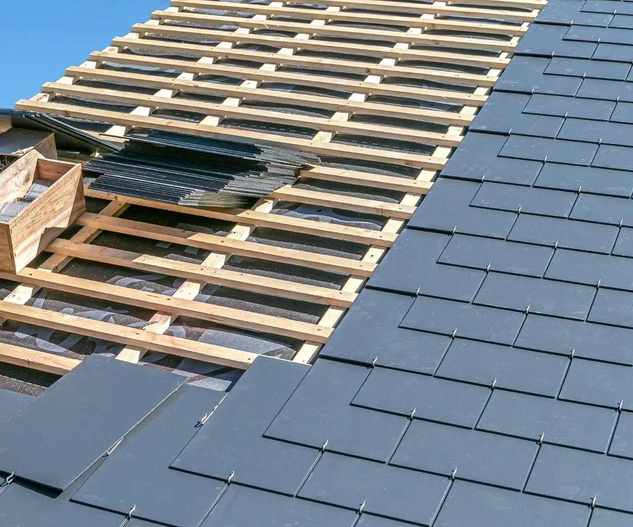 Pose d'ardoises sur toiture en préparation d'une installation de panneaux solaires par Alvea Solaire
